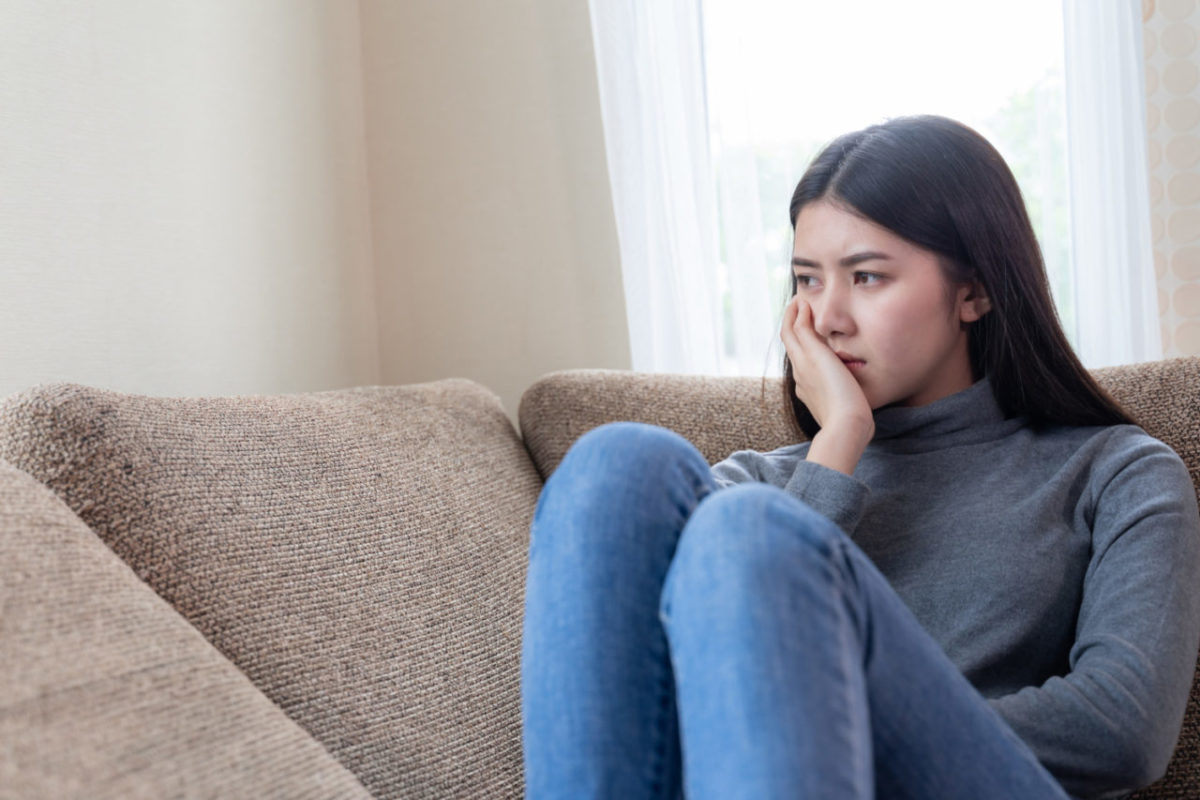 worried-woman-sitting-alone-couch