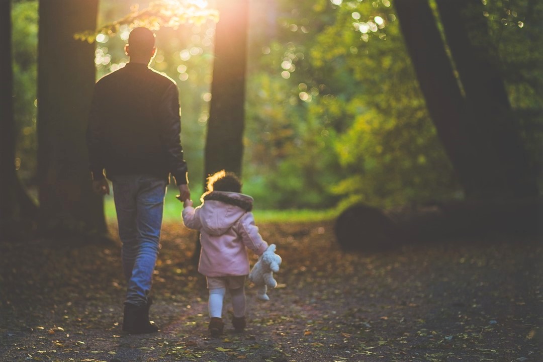 father-walking-with-her-daughter-in-forest