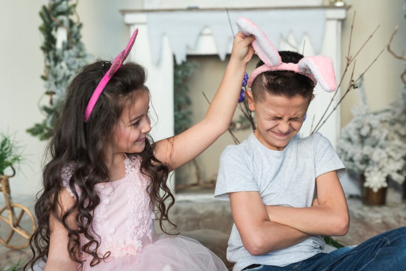 older-sister-pulling-his-young-brother-bunny-ear