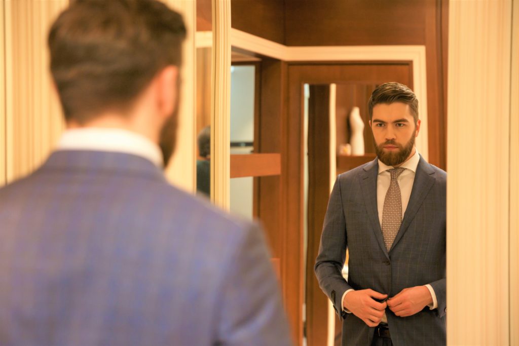 business-man-looking-into-mirror-to-check-his-suits
